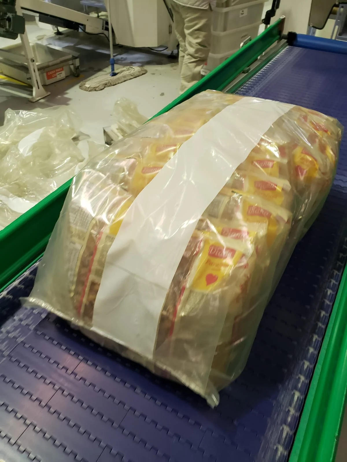 Fardo de p&atilde;es embalado em filme pl&aacute;stico na esteira industrial